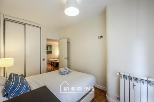 a bedroom with a bed and a table in a room at MyHouseSpain-Tranquilo apartamento con balcón in Madrid