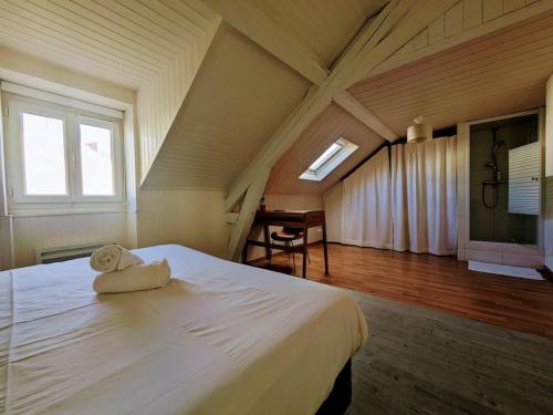 a bedroom with a large white bed in a attic at Foch, vue mer, cœur de ville in Pornic