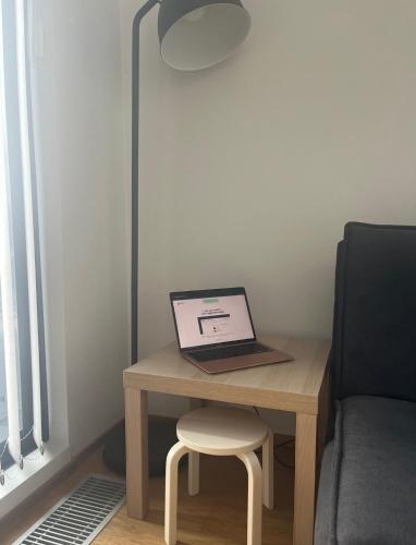 um computador portátil sentado numa mesa ao lado de uma cadeira em Spacious loft apartment with a lake view em Tampere