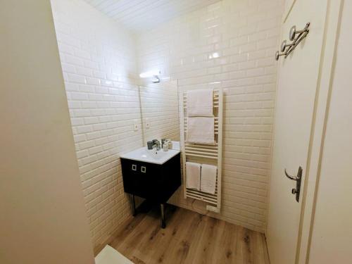 une salle de bain avec un lavabo et un miroir dans l'établissement Foch, vue mer, cœur de ville, à Pornic