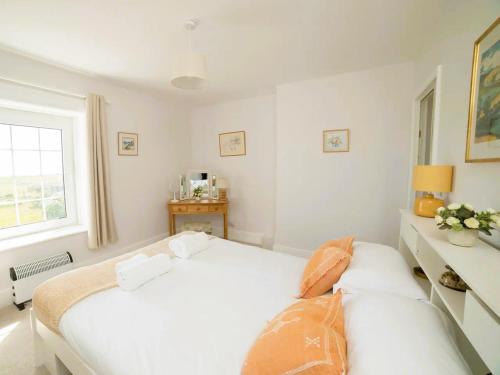 una camera da letto bianca con un letto e una finestra di Coastguard Cottage a Ventnor