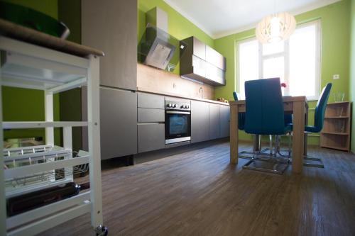 Cette chambre dispose d'une cuisine avec une table et des chaises. dans l'établissement Cozy apartment in heart of Maribor / big terrace, à Maribor