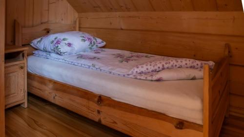 a bed in a log cabin with a pillow at Jaworowa Osada in Brenna