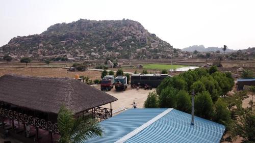 a bus parked in a parking lot in front of a mountain at Hippie Land Nature Stay in Hampi