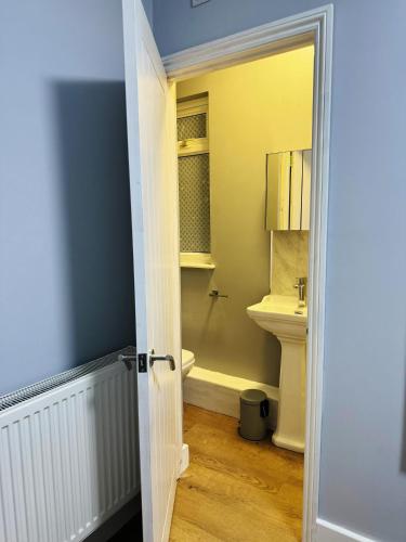 a bathroom with a toilet and a sink at Nice and Pleasant in Thornton Heath