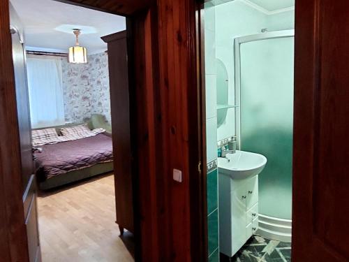 a bathroom with a sink and a bathroom with a bed at Коттеджный городок Чапаевка, Голосеевкий район in Kyiv