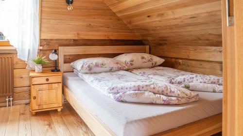 a bedroom with a bed with a wooden wall at Jaworowa Osada in Brenna