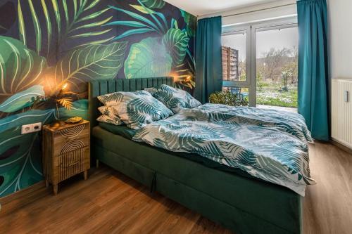 a bedroom with a bed with a tropical mural at Hotz in Radolfzell am Bodensee