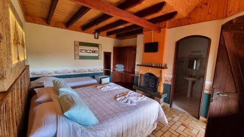a bedroom with a bed and a fireplace at Hotel Pousada Boa Montanha in Monte Verde