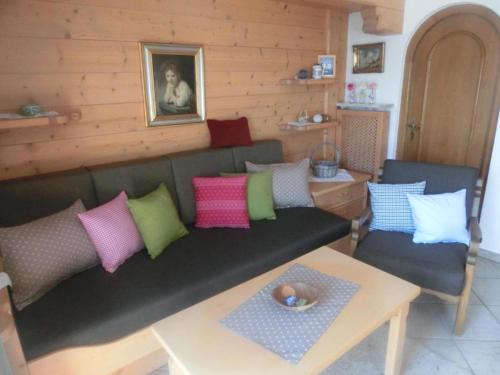 un soggiorno con divano verde e cuscini colorati di Ferienwohnung Brunnsteinnest a Mittenwald