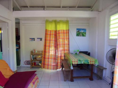 una camera con tavolo e tenda colorata di  La kaz a coyoky ad Anse-Bertrand