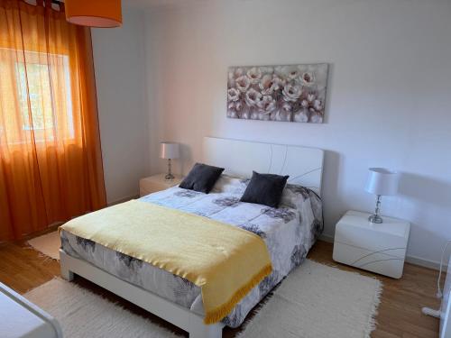 um quarto com uma cama e um quadro na parede em Moradia alegre no centro da Vila da Tocha. em Tocha