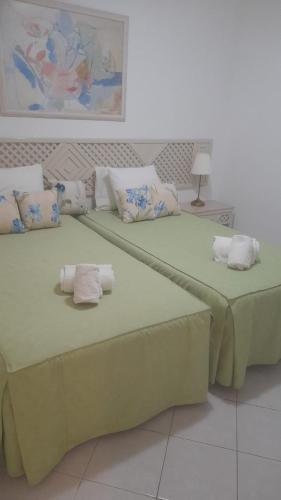two beds in a room with towels on them at Albufeira - Casa Balaia Resort in Albufeira