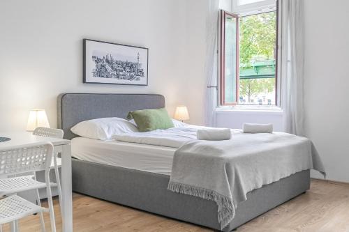 1 dormitorio con cama, mesa y ventana en Attractive 2 BR Apt. near Vienna AKH Ideal for All, en Viena