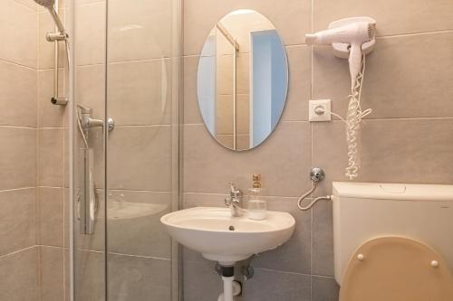 y baño con lavabo, espejo y aseo. en Attractive 2 BR Apt. near Vienna AKH Ideal for All, en Viena