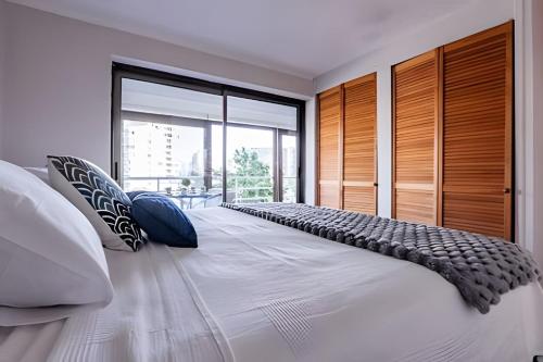 a bedroom with a large white bed with blue pillows at Estancia única y exclusiva! in Santiago