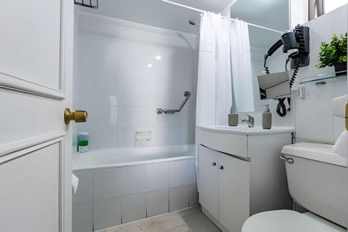 a white bathroom with a shower and a toilet at Estancia única y exclusiva! in Santiago