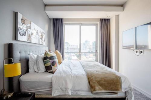 a bedroom with a large bed with a window at The Capital On the Park Self-Catering Apartments in Johannesburg