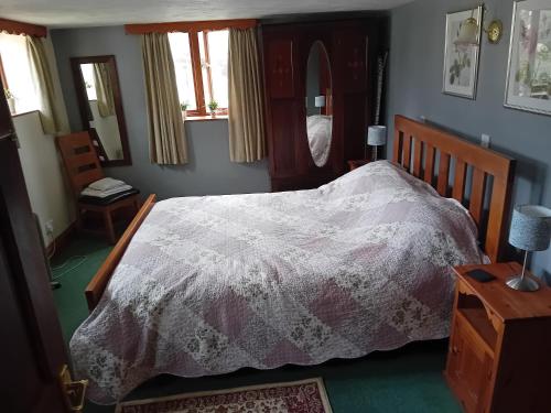 um quarto com uma cama com um edredão branco em Robins Nest em Liskeard
