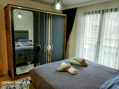 een slaapkamer met 2 handdoeken op een bed voor een spiegel bij 2+1 lüks rezidans in Istanbul