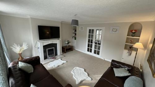 uma sala de estar com um sofá e uma lareira em Hummingbird House em Cockermouth