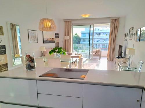 a kitchen with a white counter and a living room at Noctua Estepona Luxury Apartment Belair 005 in Estepona