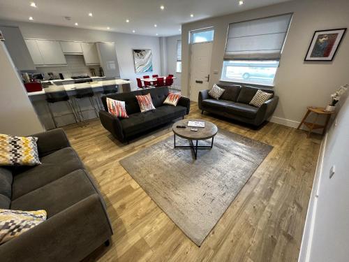 un soggiorno con divani e tavolo e una cucina di Colonels Apartment - Pet friendly a Sandown