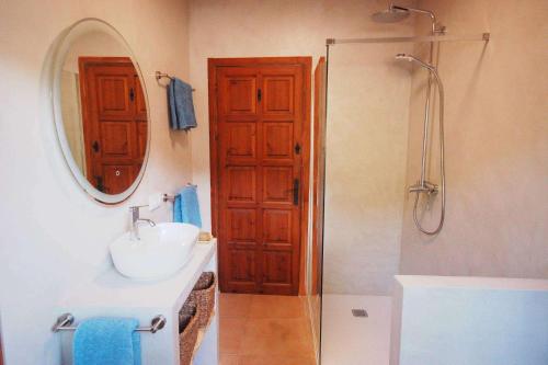 y baño con lavabo y ducha con espejo. en Villa Sophia, en Tamariu