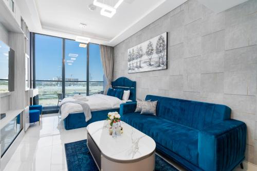 a living room with a blue couch and a bed at TAMM HOMES-SAMANA GOLF AVENUE in Dubai