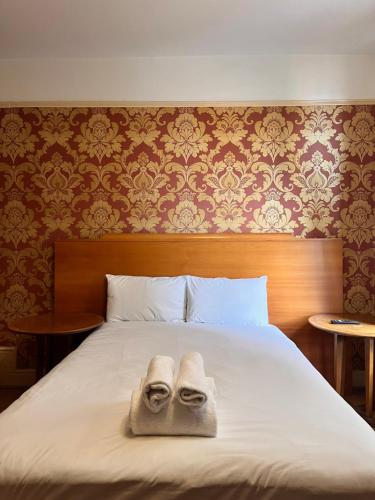two towels sitting on top of a bed at Ullet Suites in Liverpool