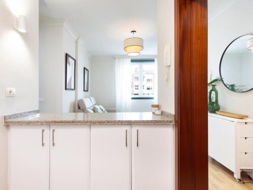 a kitchen with white cabinets and a mirror at Ek Mateo Laguna Center in La Laguna