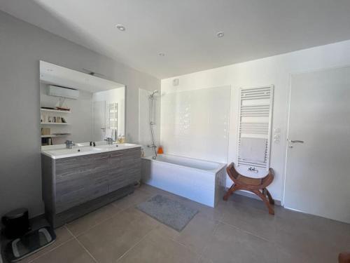 uma casa de banho branca com uma banheira e um lavatório em Splendide T3 avec piscine + Terrasse à 7 min d’Aix em Aix-en-Provence