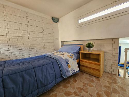 1 dormitorio con cama y pared de ladrillo en La Piccola Perla di Ortigia, en Siracusa