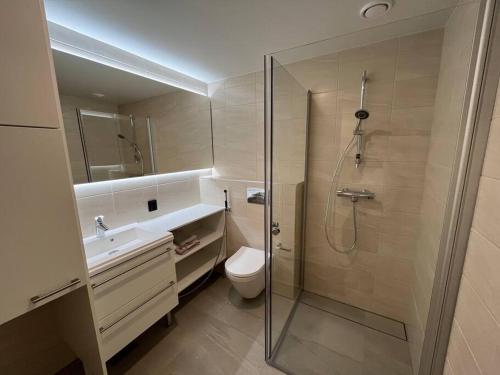 een badkamer met een douche, een toilet en een wastafel bij Moderni perhehuoneisto parhaalla sijainnilla in Espoo