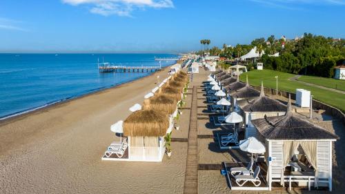 uma vista sobre uma praia com guarda-sóis e cadeiras em Sirene Belek Hotel em Belek