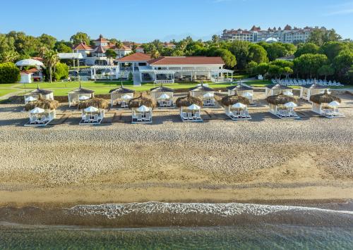 einen Blick über den Strand mit Stühlen und Sonnenschirmen in der Unterkunft Sirene Belek Hotel in Belek
