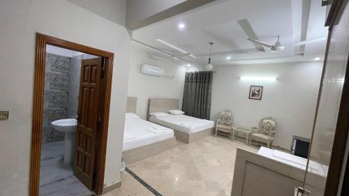 a bathroom with two beds and a sink and a mirror at Midways Guest House and Hotels in Islamabad