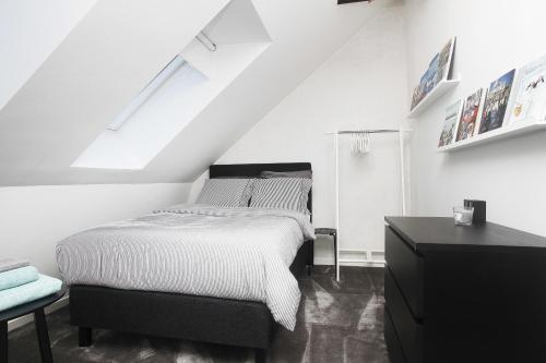 a white bedroom with a bed and a window at Villastadens Pendlarbostad in Gävle
