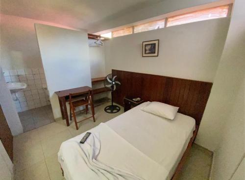 Un dormitorio con una cama y un baño con lavabo. en Happy Day Pucallpa, en Pucallpa