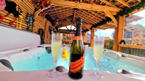 eine Flasche Wein und zwei Champagner-Gläser in der Badewanne in der Unterkunft Beresford Cottage in Skegness