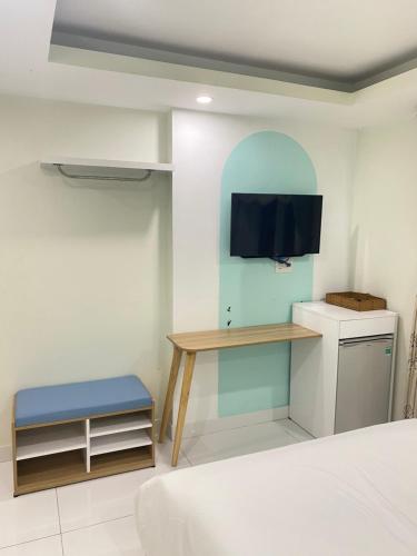 1 dormitorio con escritorio y TV en la pared en Khách Sạn Bãi Dâu 178 Trần Phú Vũng Tàu, en Vung Tau