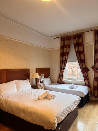 a hotel room with two beds and a window at Beech Mount Grove Suites in Liverpool