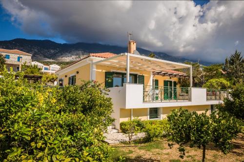 a large yellow house with a balcony at Villa Petri in Trapezaki