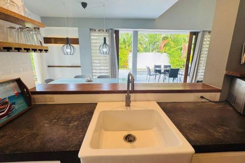 eine Küche mit einem Waschbecken und Blick auf ein Schlafzimmer in der Unterkunft Private Garden Villa in Las Terrenas