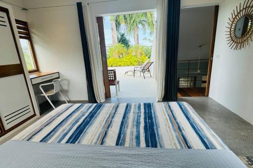 a bedroom with a large bed and a large window at Private Garden Villa in Las Terrenas