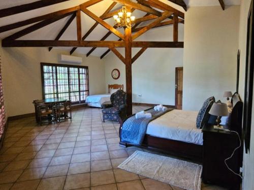 a bedroom with two beds and a table in a room at Arum Lily Eloff in Delmas
