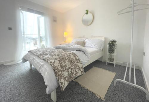 a white bedroom with a bed and a mirror at Beach Retreat in Bournemouth