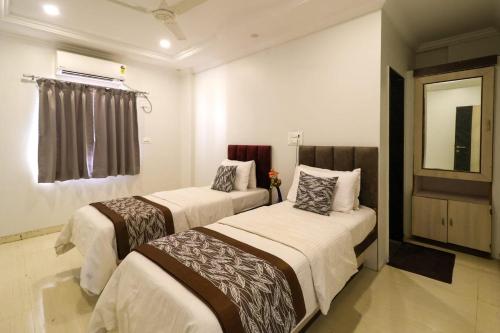 a bedroom with two beds in a room at Hotel Jeet Paradise in Phaltan