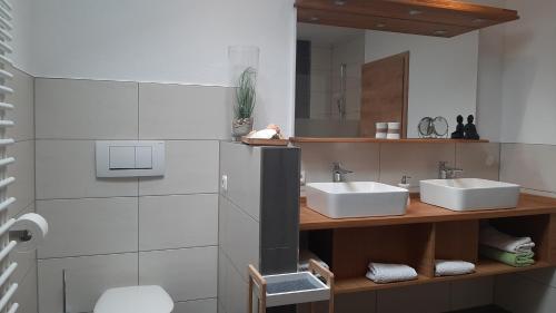 uma casa de banho com 2 lavatórios e um espelho em Ferienwohnungen Geier em Niederalteich