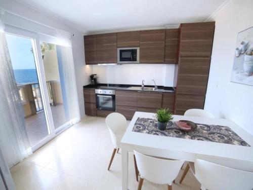 a kitchen with a table and chairs and a kitchen with the ocean at Las Velas B in La Manga del Mar Menor